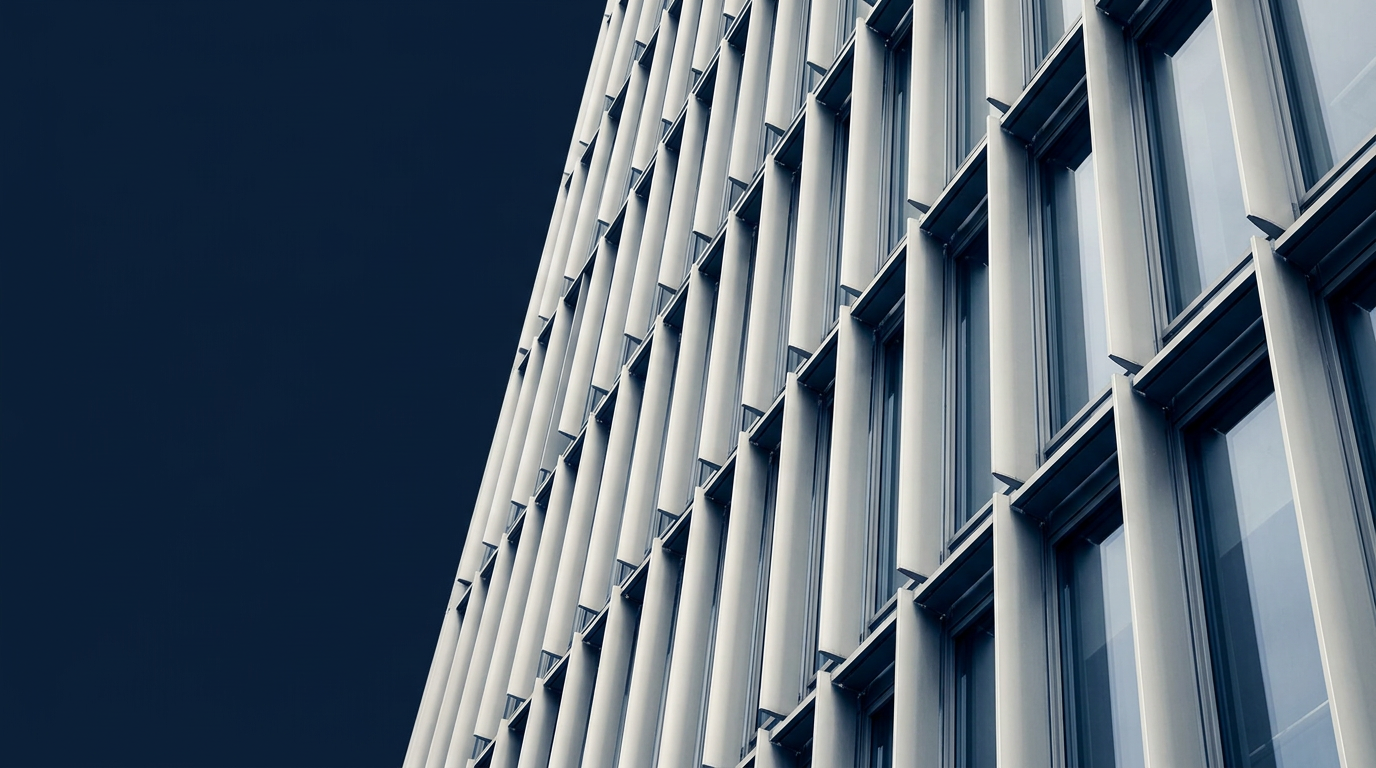Abstract architectural view of silver building fins against a deep navy sky